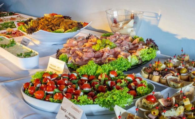 Vielfalt an appetitlichen Vorspeisen mit Salat, Wurst und Canapés auf einem Tisch.